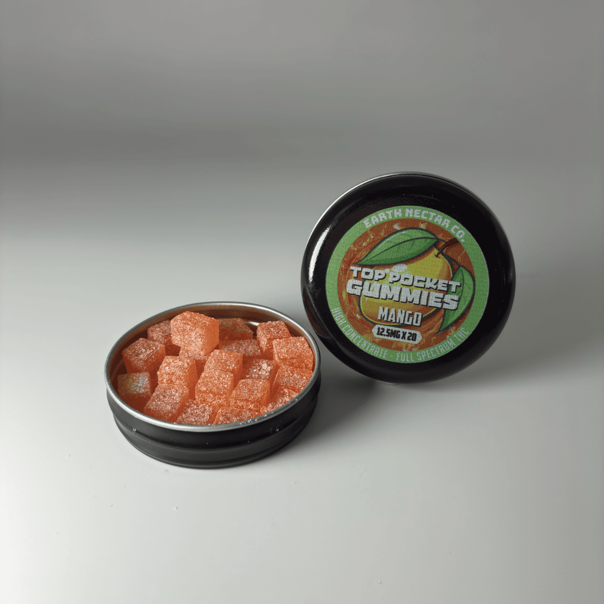 Earth Nectar Co. Top Pocket Gummies in Mango, open tin of THC mini gummies beside the sealed tin