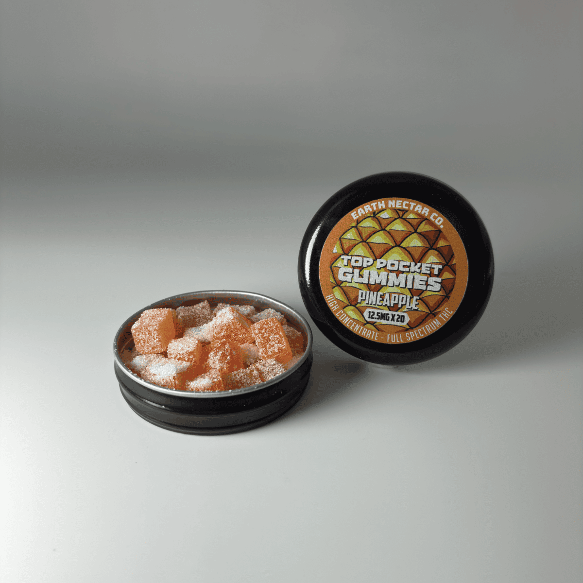 Earth Nectar Co. Top Pocket Gummies in Pineapple, open tin of THC mini gummies beside the sealed tin